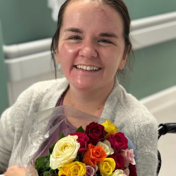 Rebecca holding flowers in hospital