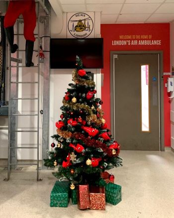 A decorated Christmas tree and Father Christmas' leg decoration at London's Air Ambulance's helipad
