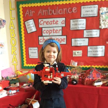 Pupil holding her London's Air Ambulance helicopter model