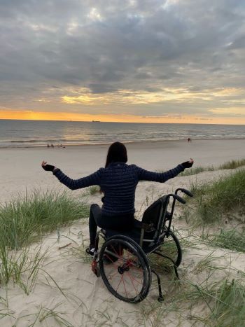 Vaiva in her wheelchair on a beach