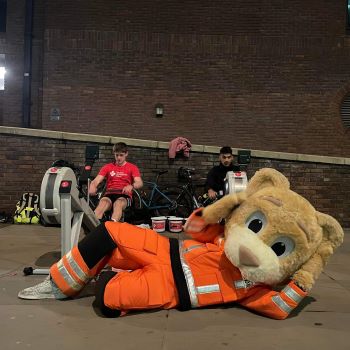 Dr Ted, London's Air Ambulance Charity's mascot, lying next to the rowers