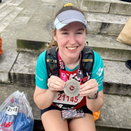 Emily holding her medal after running the London Marathon