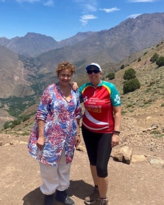 Two hikers with mountains in the background.