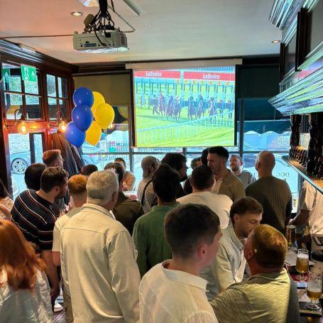 People watching old races in a pub